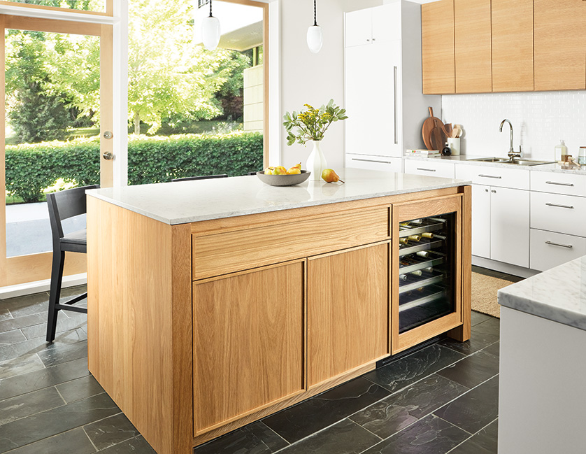 Kitchen with Amherst kitchen island with glass door fridge, polar pendant lights and Selby rug in taupe.